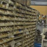 Industrial shelving unit packed with labeled cardboard boxes in warehouse storage facility
